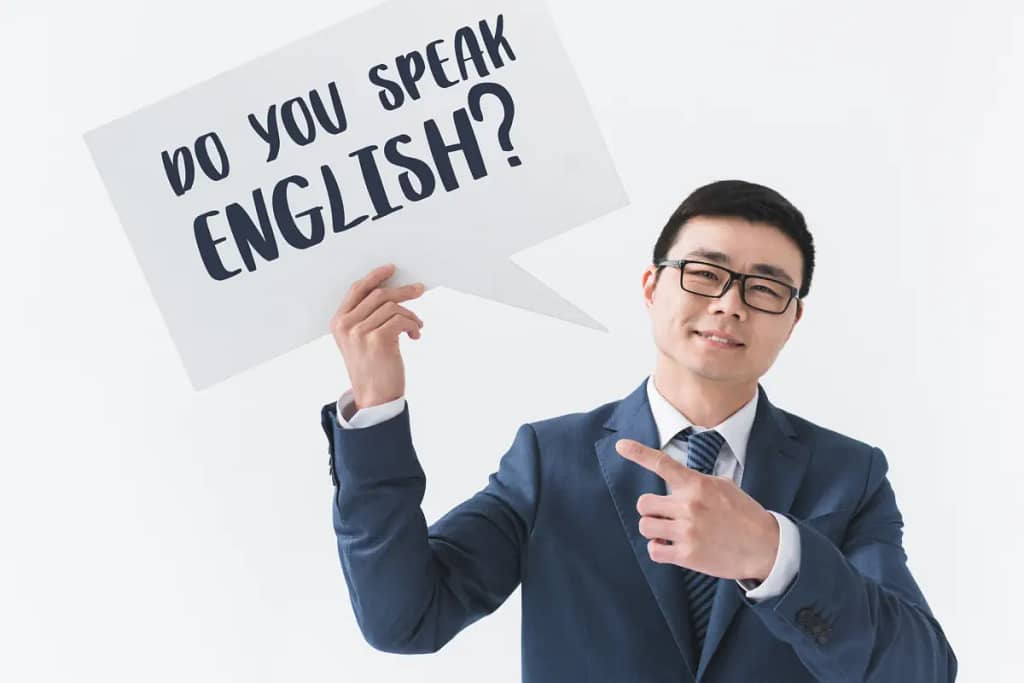 Biznesmen trzymający znak z zapytaniem, czy mówisz po angielsku